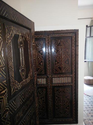a pair of wooden doors in a room at Hotel Coeur de Mogador in Essaouira