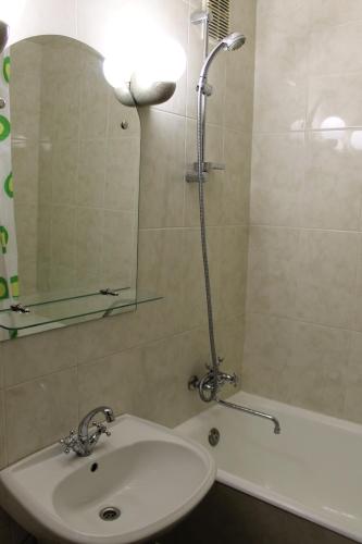 y baño con lavabo y ducha con espejo. en KyivStay Vvedenska Apartment, en Kiev