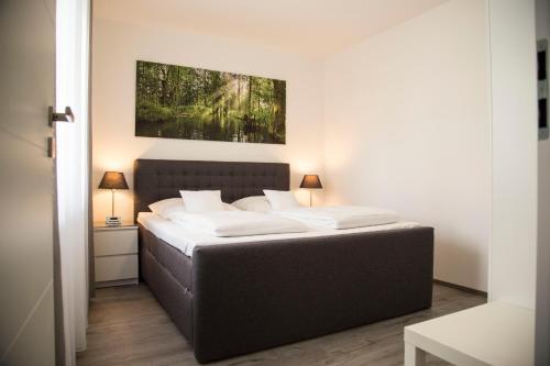 a bedroom with a large bed with white sheets at Spreehaus-Apartments in Lübben