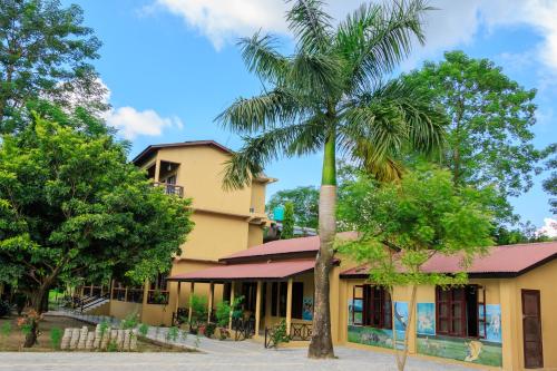 a palm tree in front of a building at Tiger Residency Resort in Sauraha