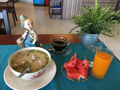 a table with a bowl of soup and a plate of watermelon at Samed Port View in Ko Samed