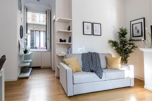 ein Wohnzimmer mit einem weißen Sofa und einem Fenster in der Unterkunft JOIVY Lovely Flat for 5 close to Sforzesco Castle in Mailand