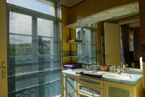 baño con lavabo, espejo y ventana en Hotel La Diligence en Honfleur