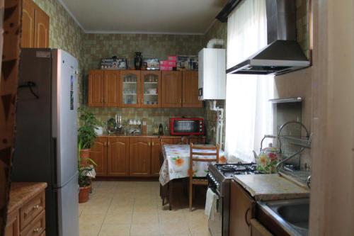 a kitchen with a refrigerator and a stove top oven at Nona Guest House in Shilda