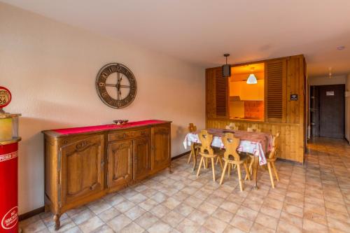 a dining room with a table and a clock on the wall at Appt les Granges - Vue montagne et village, Centre la Clusaz - AravisTour in La Clusaz