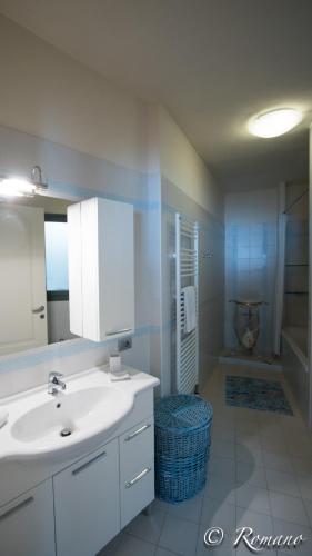 a bathroom with a sink and a mirror and a tub at Villa Montefontane in Camporosso