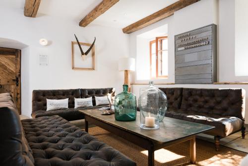 a living room with leather couches and a table at Hotel & Gourmetwirtshaus Kirchenwirt seit 1326 in Leogang