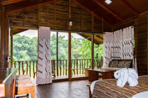 a bedroom with two beds and a balcony at Kandy Cabana in Kandy