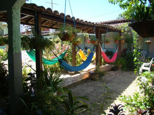 a patio with hammocks hanging from a pergola at Algodoal Bela Mar Pousada in Algodoal
