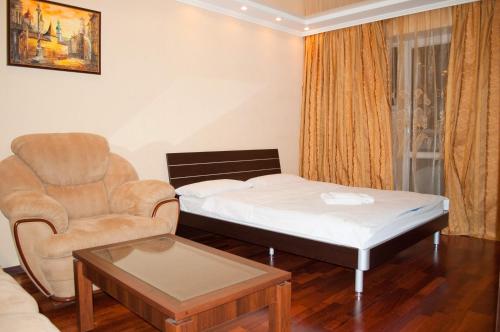 キーウにあるKyivStay Pochaynynska Apartmentのベッド1台、椅子、ソファが備わる客室です。