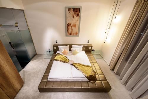 a bedroom with a bed with a yellow blanket on it at Karoly Corner Residences in Budapest