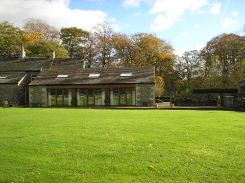 una casa con un grande campo verde davanti di Green Grove Country House a Malham