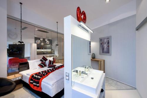 a bedroom and a living room with a bed and a sink at Karoly Corner Residences in Budapest