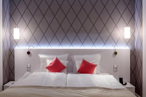 a bedroom with a white bed with red pillows at Karoly Corner Residences in Budapest