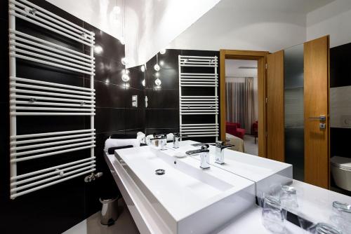 a bathroom with a white sink and a mirror at Karoly Corner Residences in Budapest