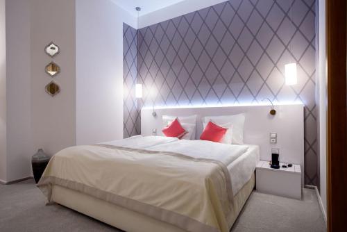 a bedroom with a large white bed with red pillows at Karoly Corner Residences in Budapest
