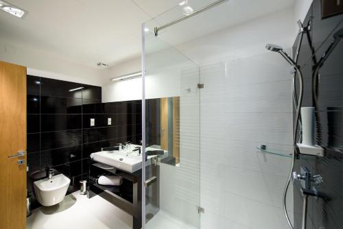 a bathroom with a sink and a glass shower at Karoly Corner Residences in Budapest
