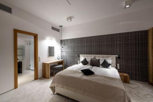 a bedroom with a large bed with a brick wall at Karoly Corner Residences in Budapest