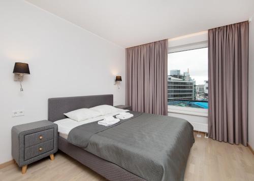 a bedroom with a bed and a large window at 8ERA Business Executive Rotermanni Apartments in Tallinn