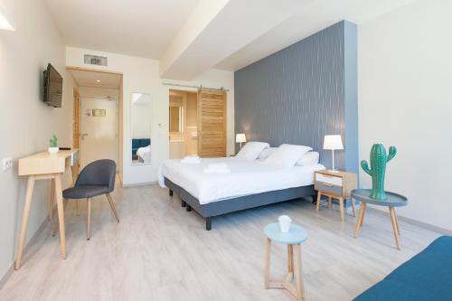 a hotel room with a bed and a cactus at Hotel Restaurant des Maures in Collobrières