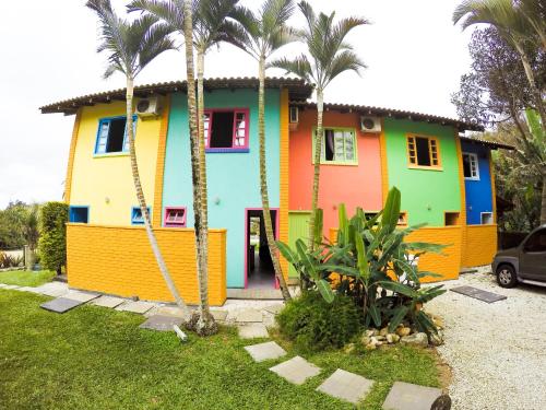 a colorful house with palm trees in front of it at O Costão do Sol in Balneário Camboriú