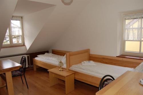 two beds in a room with two tables and a table at Penzion Markus - Pivovar - Brewery Frymburk in Frymburk