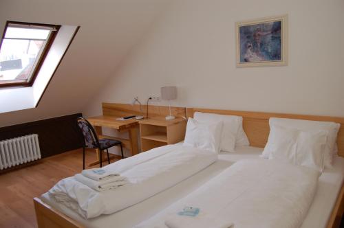 a bedroom with a bed with a desk and a window at Penzion Markus - Pivovar - Brewery Frymburk in Frymburk