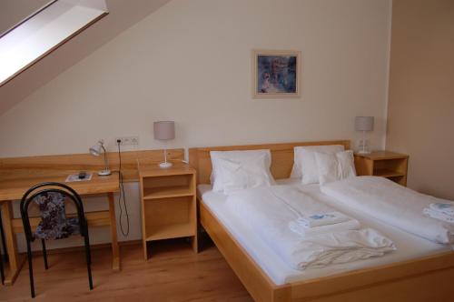 a bedroom with a bed and a desk with a chair at Penzion Markus - Pivovar - Brewery Frymburk in Frymburk