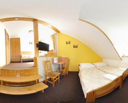 a room with a bed and a table in a room at Willa Hamernik AGROTURYSTYKA in Tylicz