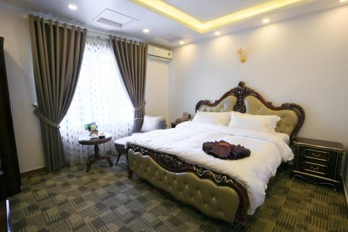 a bedroom with a large bed and a window at Pham Ha Hotel in Hai Phong
