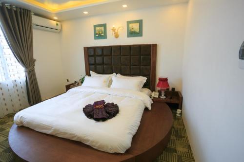 a bedroom with a large bed with areath on it at Pham Ha Hotel in Hai Phong