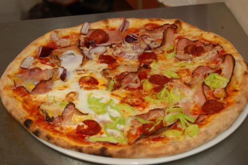 a pizza sitting on a plate on a table at Penzion Markus - Pivovar - Brewery Frymburk in Frymburk