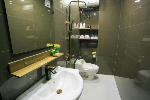 a bathroom with a white sink and a toilet at Pham Ha Hotel in Hai Phong