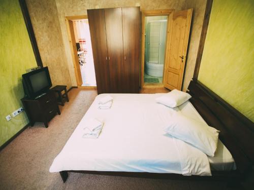 ボロフタにあるГотель Добрійのベッドルーム(白いベッド1台、テレビ付)