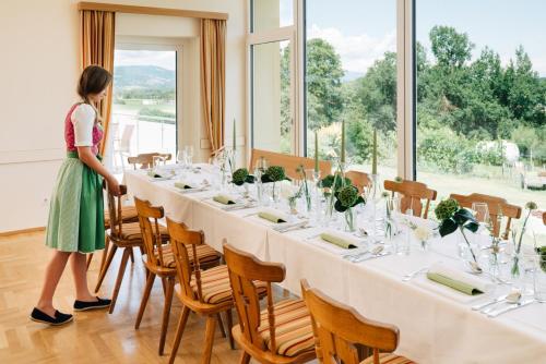 a woman standing in front of a long table at Gasthof Martinhof in Sankt Martin im Sulmtal