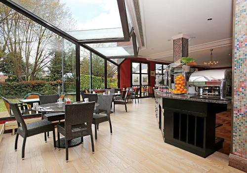 a restaurant with a fireplace and tables and chairs at Millennium Hotel Paris Charles De Gaulle in Roissy-en-France