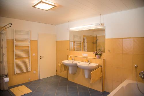 a bathroom with two sinks and a tub and a mirror at Ferienhaus Schmiedehof in Hitzing