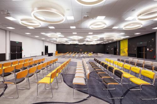 an empty conference room with yellow chairs in it at Novotel Warszawa Airport in Warsaw