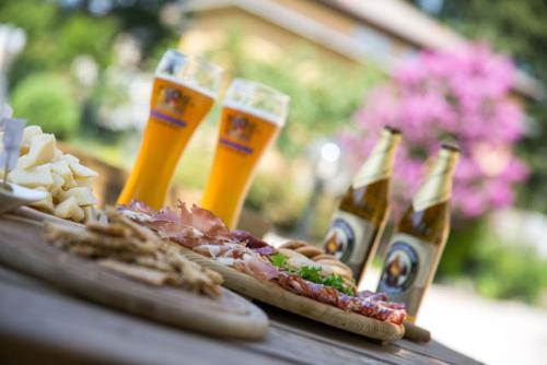 a table with three bottles of beer and food at Hotel Daniela in Levico Terme
