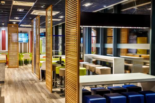 a dining room with blue chairs and tables at ibis budget Luton Airport in Luton