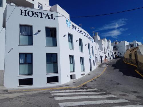 a white building with a hospital sign on the side of it at Hostal Brisas de Conil in Conil de la Frontera