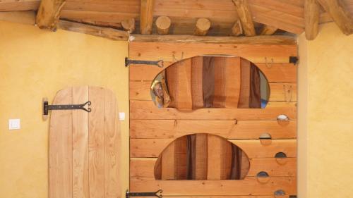 a room with a wooden wall with a door at Cabane-hobbit de Samsaget in Eyvignes-et-Eybènes