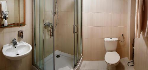 a bathroom with a shower and a toilet and a sink at Hostel Fortis in Ostrołęka