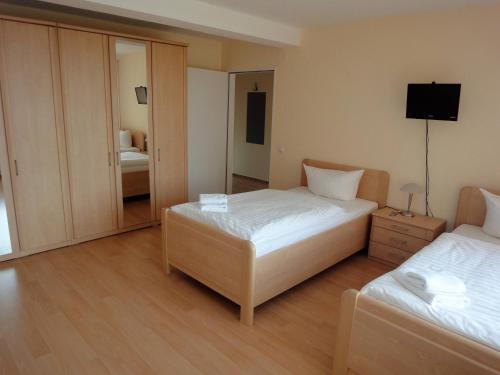 a hotel room with two beds and a mirror at Forsthaus Appartements in Braunschweig