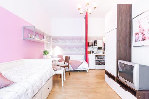 ベルリンにあるSüßes 1-Zimmer-Apartment in Kollwitzplatz-Näheのベッド1台とテレビが備わる小さな客室です。