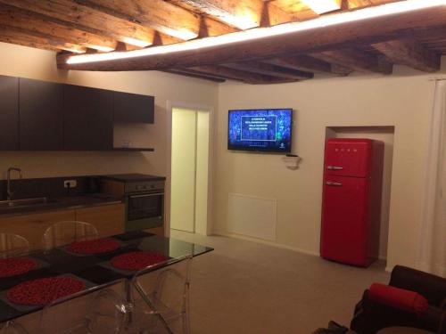 uma cozinha com um frigorífico vermelho e uma televisão na parede em Gioiello di Venezia, Suite San Lio em Veneza