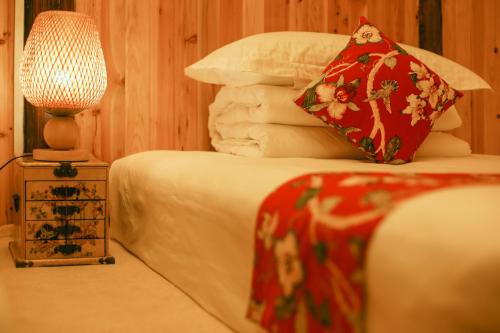 a bedroom with a bed with a red pillow and a lamp at Ridge Inn in Longsheng