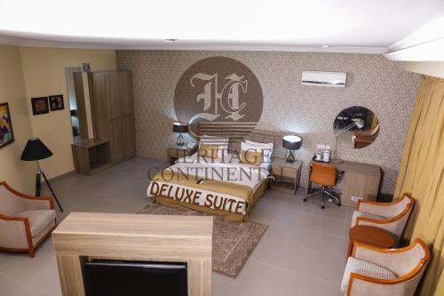 a living room with a bed and a table and chairs at Heritage Continental Hotel in Akure