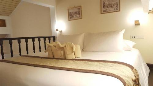 a bedroom with a bed with white sheets and pillows at Chuchaiburi Sri Amphawa in Amphawa