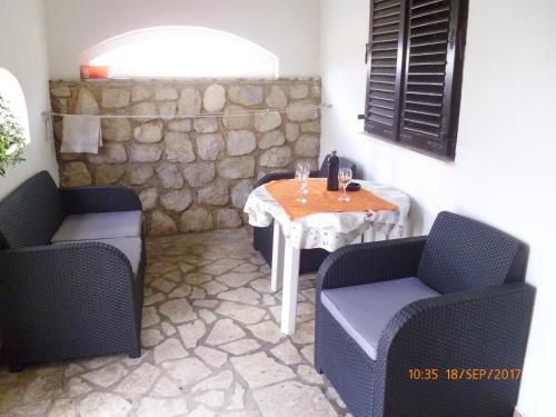 a table and two chairs and a table and a table and chairs at Apartments Lidija in Pag